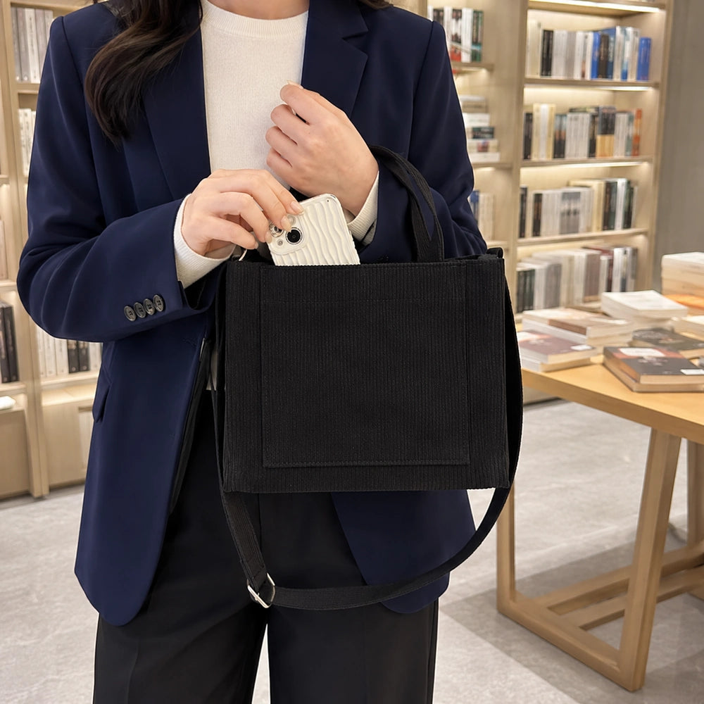 Tote bag velours noir porté par une femme