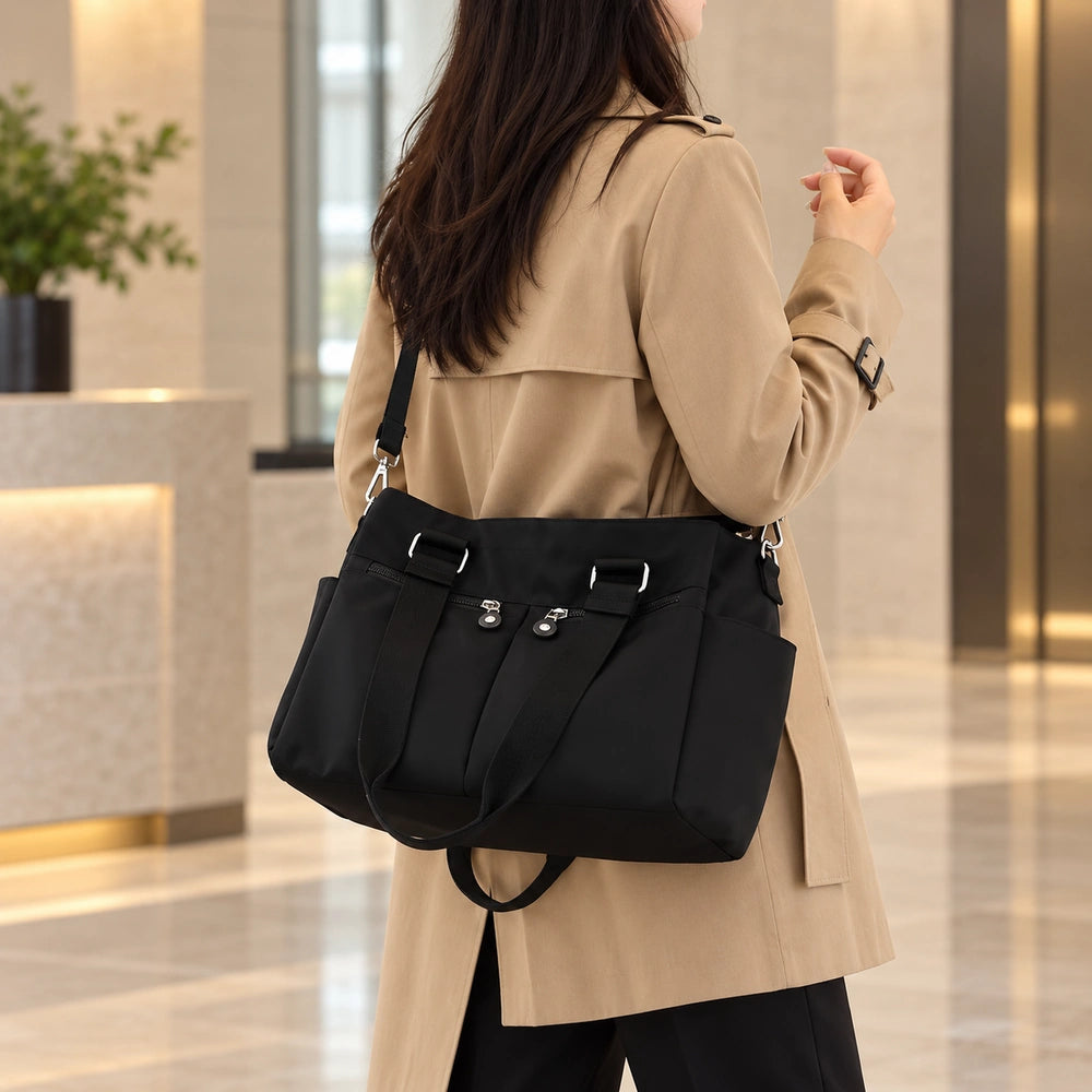 Grand sac à main multipoches noir porté à l’épaule